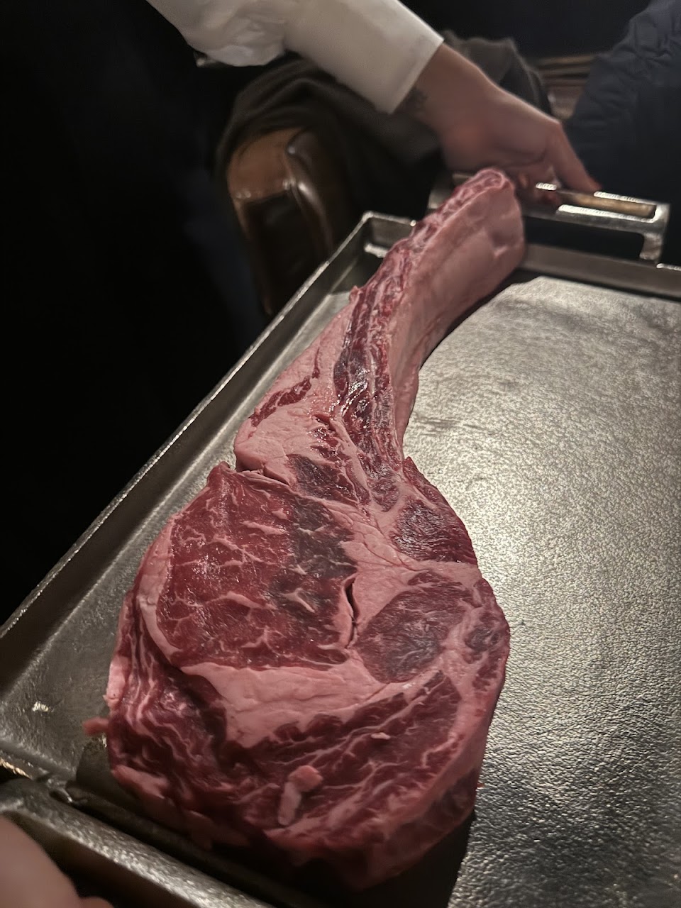 Raw tomahawk steak presented tableside at 6HEAD Sydney